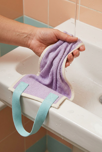 Hands rinsing the lavender back towel over a basin
