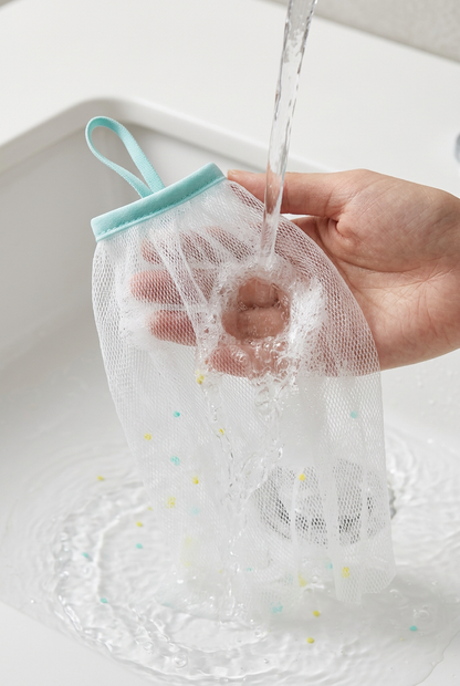 White mesh foaming net being rinsed over a basin