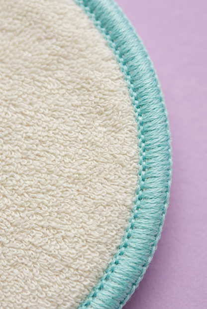 Close-up of ivory textile pad surface and aqua stitched rim
