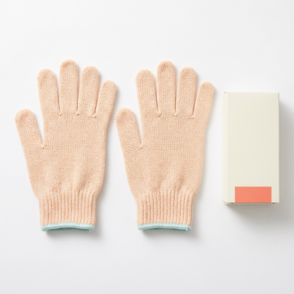 Two peach knitted bath gloves with aqua trim and carton on white