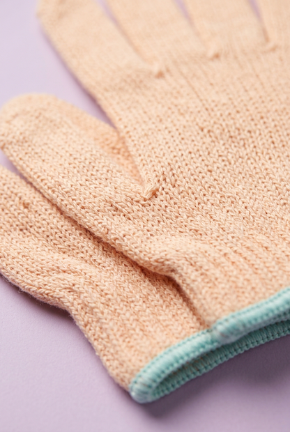 Close-up of peach knit and aqua-edged cuff